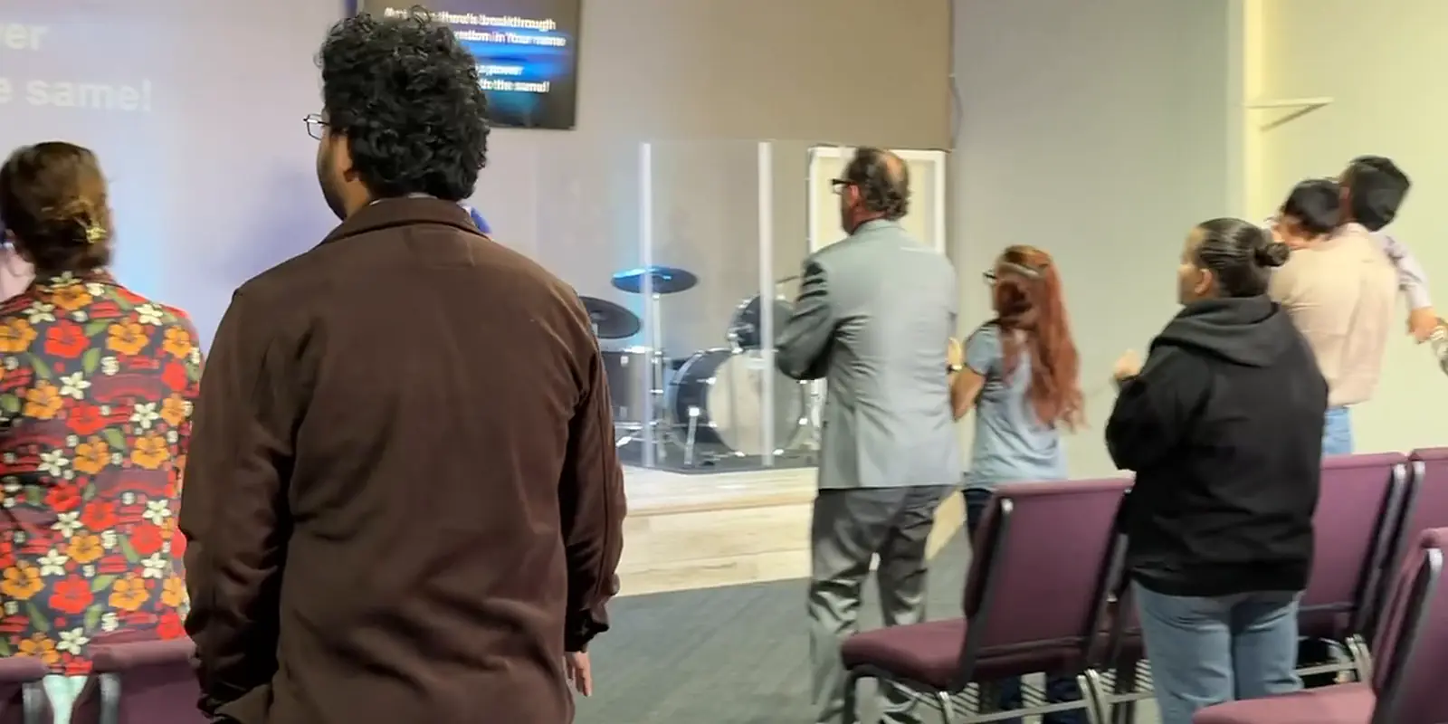 People standing together during worship at our Sunday service.